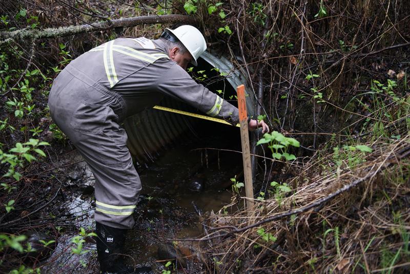 Inspector measures the width of the culverts 