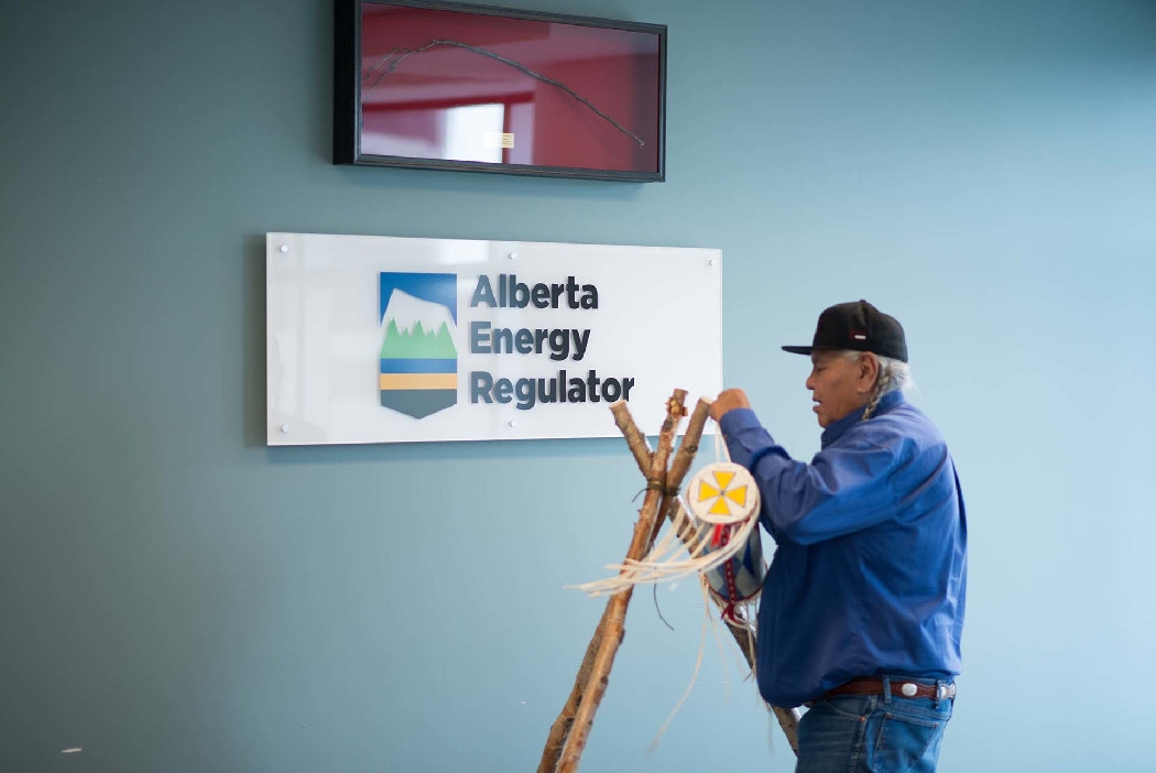 Blackfoot Elder Dr. Reg Crow Shoe places the AER’s bundle on its birch pole stand