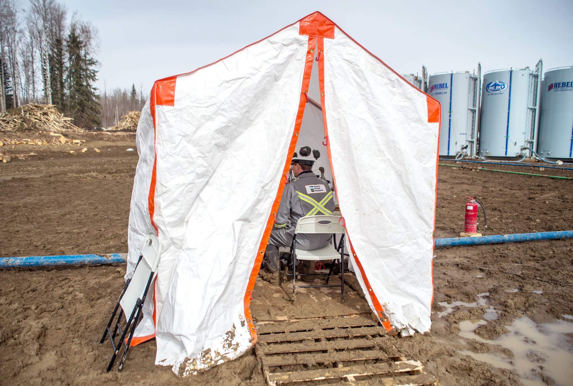 AER staff take shelter to collect gas and aerosol samples from a pipeline running between the separator and the flare stack