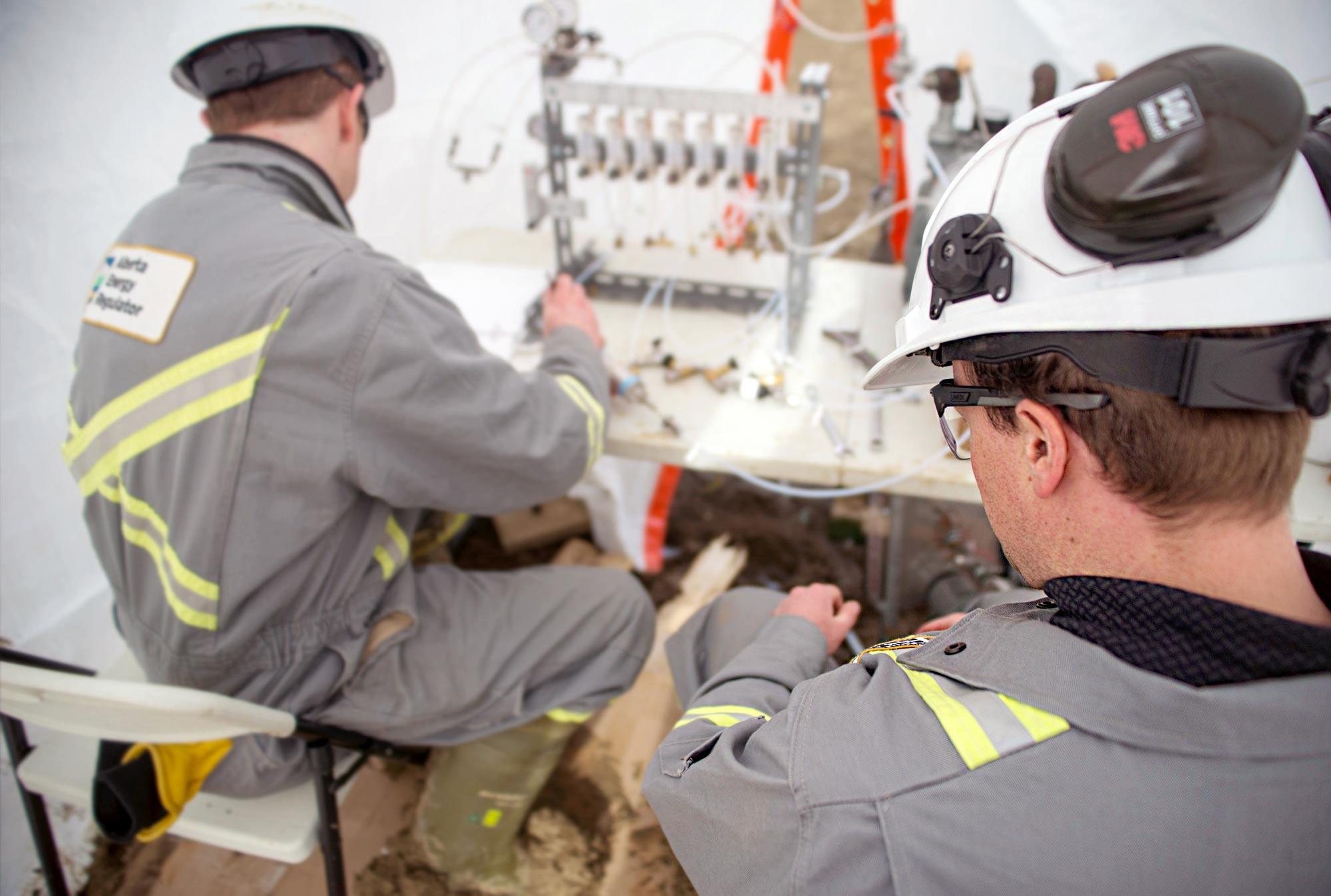 AER field inspectors, Jeffrey MacInnis and Dean Thompson collecting samples